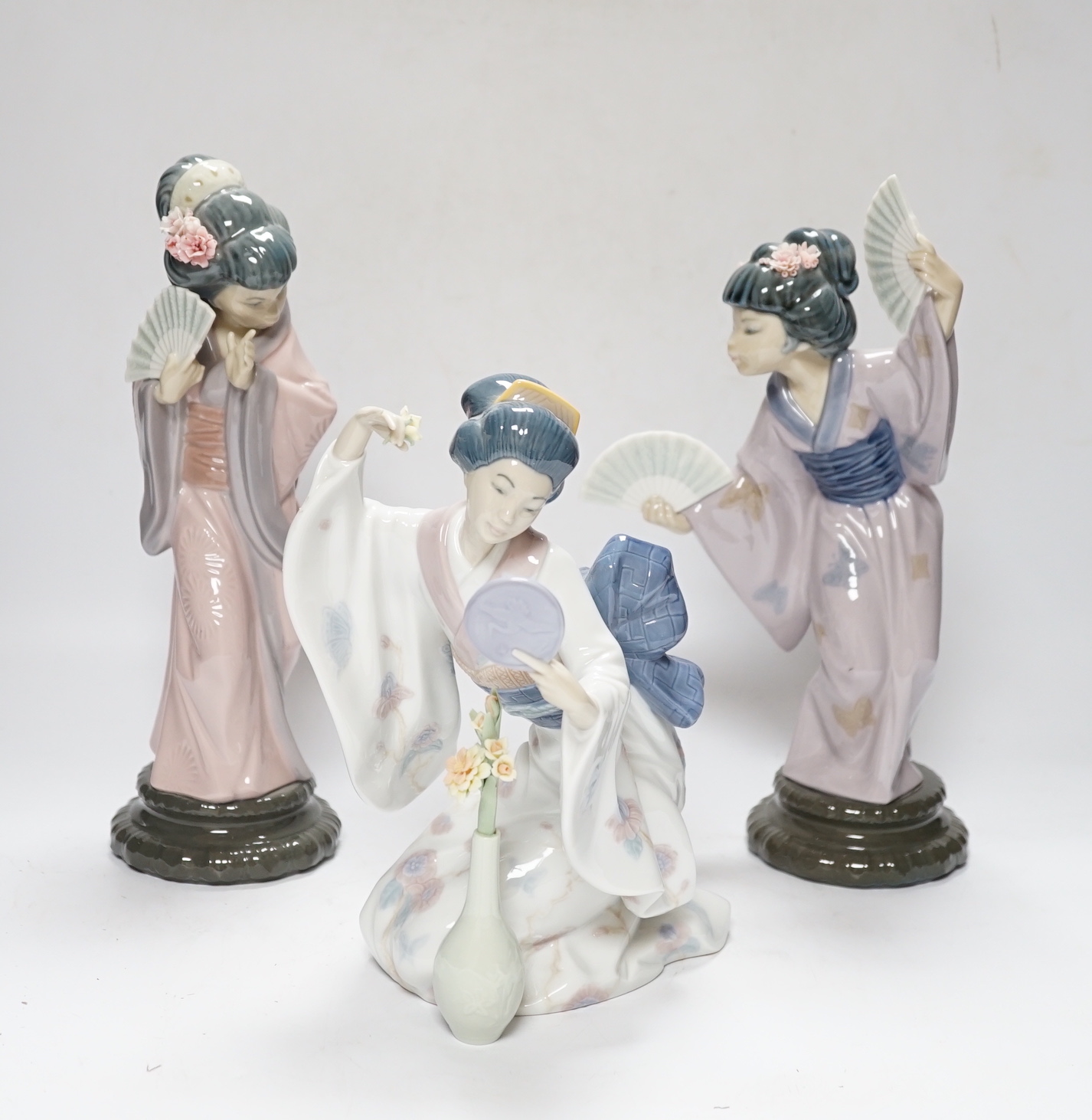 Three Lladro figures, Mirror Mirror, and two Japanese Geisha girls holding fans, (one boxed) tallest 29cm high